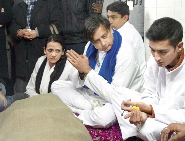 Shashi Tharoor with Sunanda’s son from a previous marriage, Shiv Menon, during her cremation on Saturday. Pic/AFP