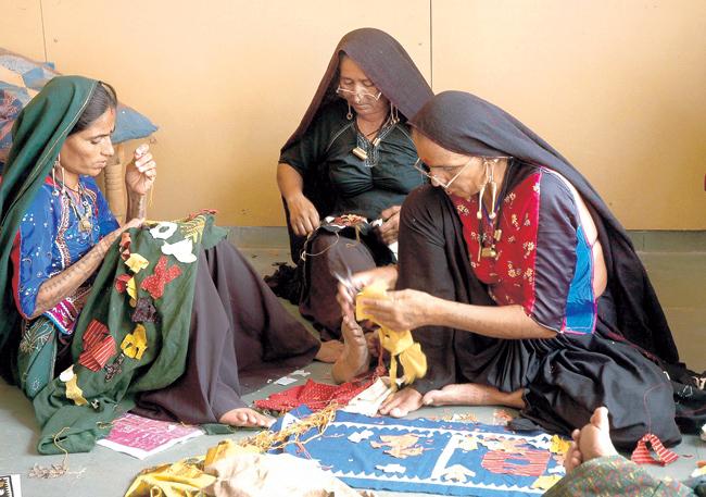 Women from Kala Raksha creating intricate embroidered pieces