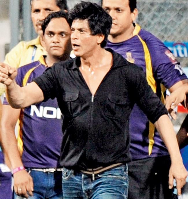SRK gestures towards a security guard at the Wankhede Stadium in 2012. Pic/AFP