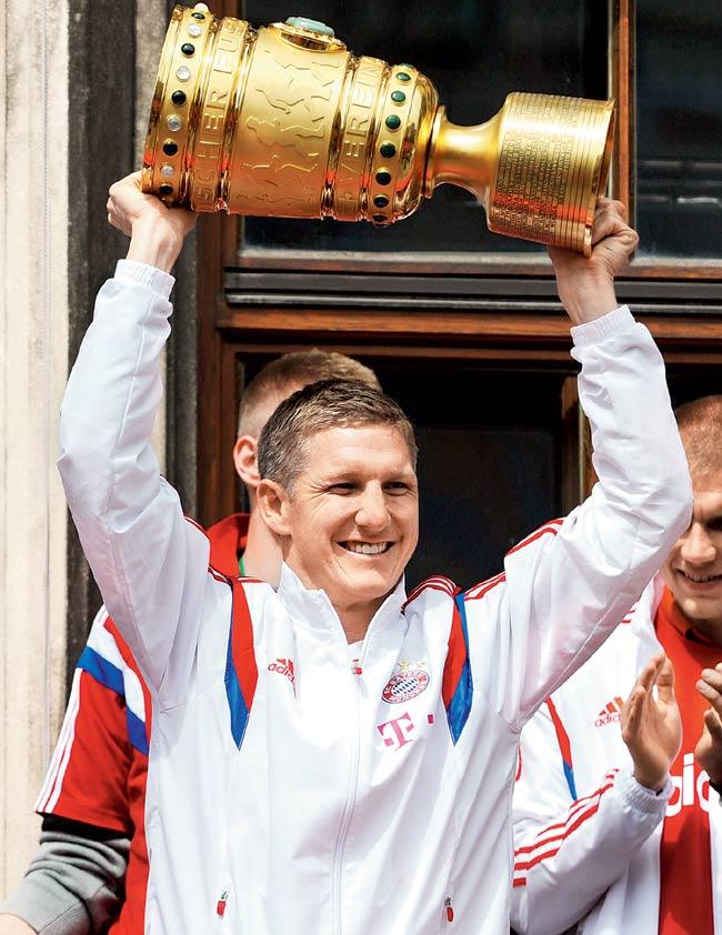 Bayern Munich midfielder Bastian Schweinsteiger with the winners trophy