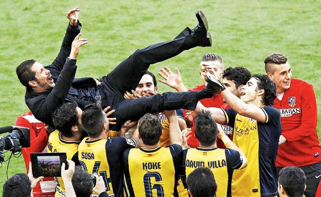 Atletico Madrid coach Diego Simeone is tossed by his players as they celebrate their Spanish league title on Saturday. Pic/AFP