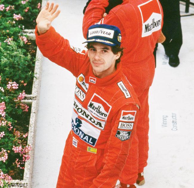 Ayrton Senna waves from a podium after winning the Belgian Grand Prix in 1989. Pic/Getty Images