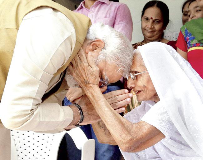 A victorious Narendra Modi seeks blessings of his mother Hiraba at her home in Gandhinagar on Friday as election results showed a landslide win for BJP. Pic/PTI