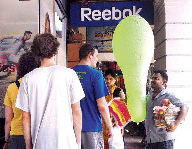 A vendor tries to sell his wares to foreign tourists at Colaba. Pic/Atul Kamble