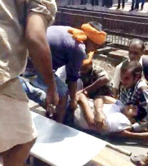 Passengers help an unresponsive Vijay Nisar off the tracks and on to a stretcher