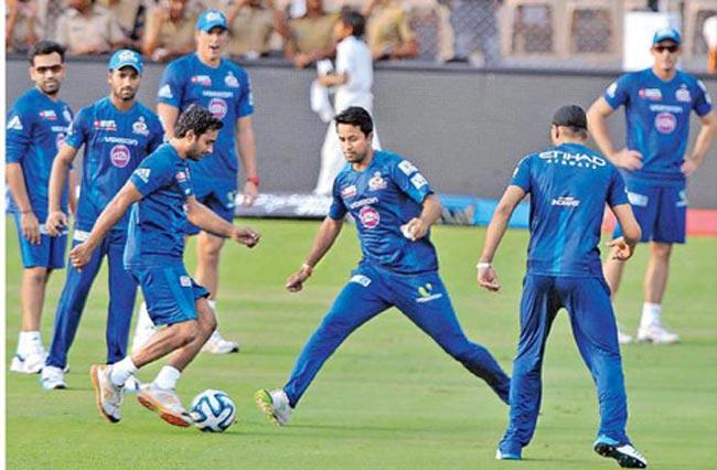 Eyes on the ball: Mumbai Indians players warm up with a game of football. Pic/Suresh KK