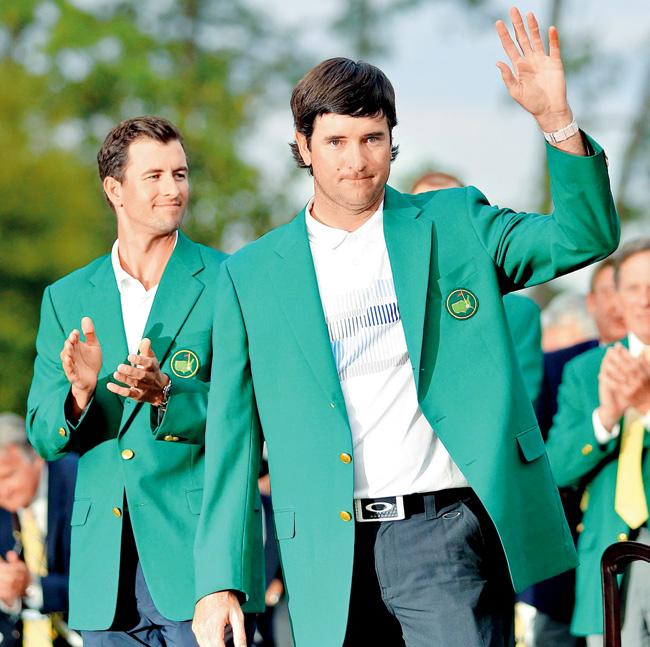 Bubba Watson poses with the green jacket as Adam Scott looks on. Pic/Getty Images