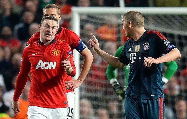 Bayern Munich-s German midfielder Bastian Schweinsteiger R talks to Manchester United-s English striker Wayne Rooney L as he leaves the field after being sent off for a tackle on Rooney during the UEFA Champions League quarter-final first leg football match between Manchester United and Bayern Munich at Old Trafford in Manchester. Pic/AFP