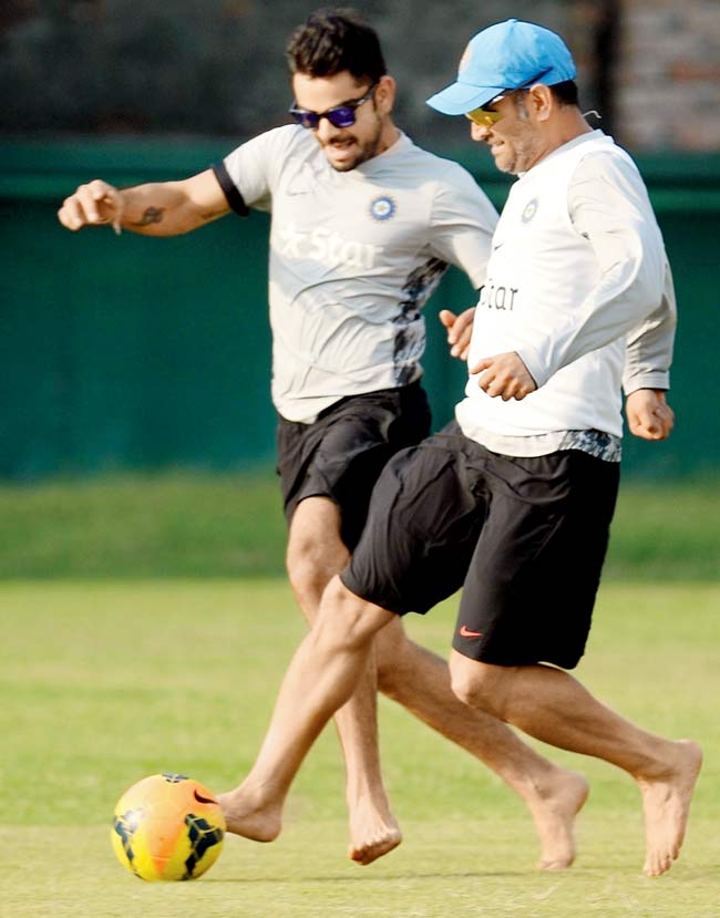 MS Dhoni (right) and Virat Kohli play football during a training session in Dhaka yesterday. Pics/AFP