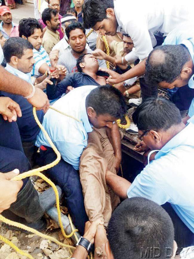 Morning madness: Residents hurried out of their homes when an inebriated Rahul Rajage plunged into the well. A team of nine firemen finally pulled him out after securing his waist with ropes. Pics/Mohan Patil