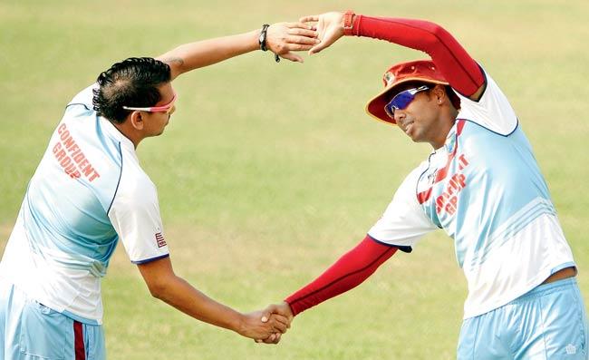 West Indies spinners Samuel Badree (right) and Sunil Narine warm up during a training session at the Sher-e-Bangla National Cricket Stadium in Dhaka yesterday. Pics/AFP