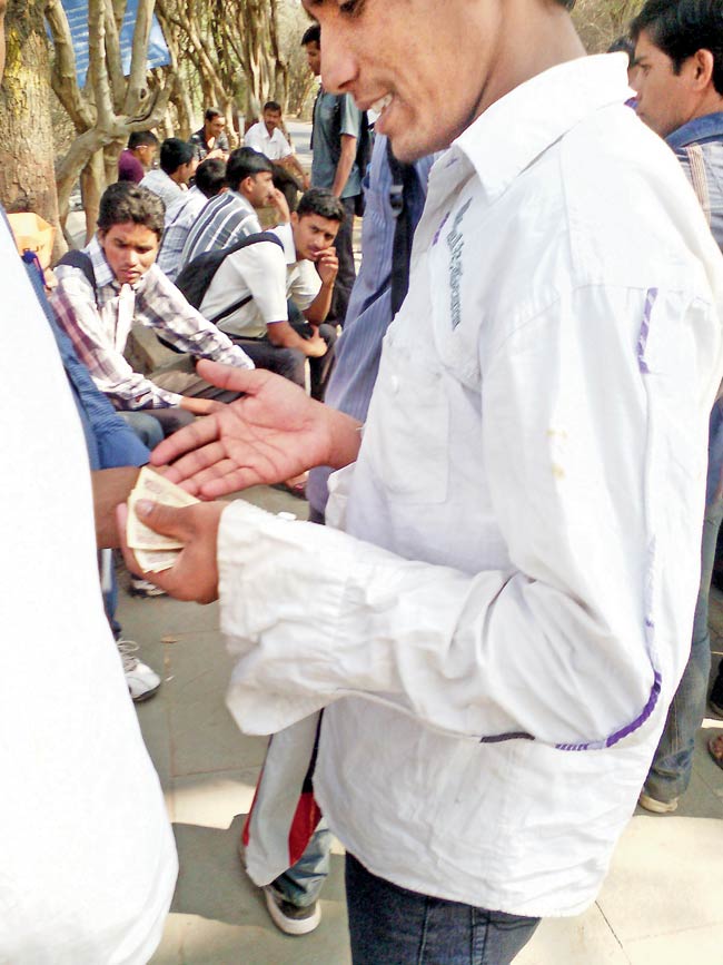Money matters: An activist is seen handing out money to the students outside Shivaji Garden, University of Pune