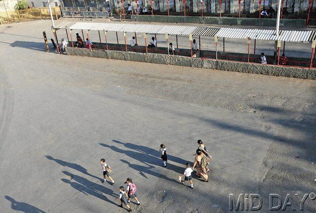 Children cross the bus stop outside the Bandra railway station and make their way to school; many have final exams going on.  Pic/Satyajit Desai