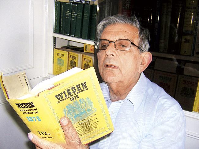 Dicky Rutnagur with an old copy of Wisden
