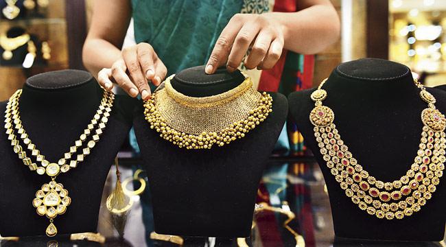 A jewellery store employee arranges gold necklaces at a newly-launched showroom in Ahmedabad. PIC/AFP