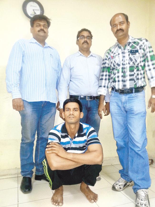 Officials from Unit XI of the Crime Branch with serial robber Harun Jaydev Sardar (sitting)