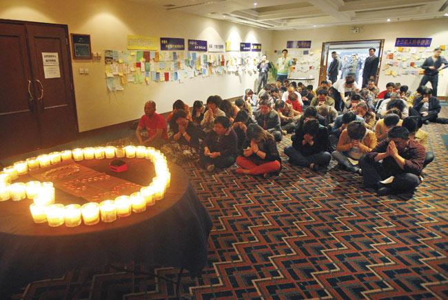 Relatives hold a prayer session at a hotel in Beijing, as the search for plane moved underwater. Pic/Imagelibrary/EPA