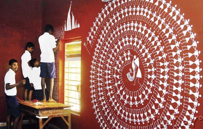 Students work on Warli painting by artist Rajesh Chaitya Vangad as part of Wall Art in Dahanu
