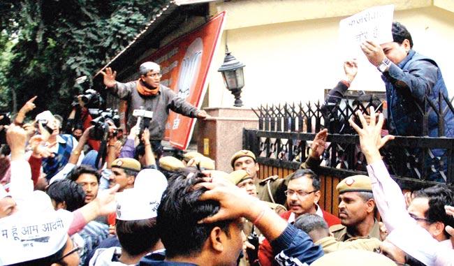 For your viewing pleasure: Enraged over Arvind Kejriwal’s detention in Gujarat, AAP leader Ashutosh clambered on to the boundary wall of the BJP office in Delhi and raised slogans, all the while playing to the live TV cameras with flourish. Pic/PTI