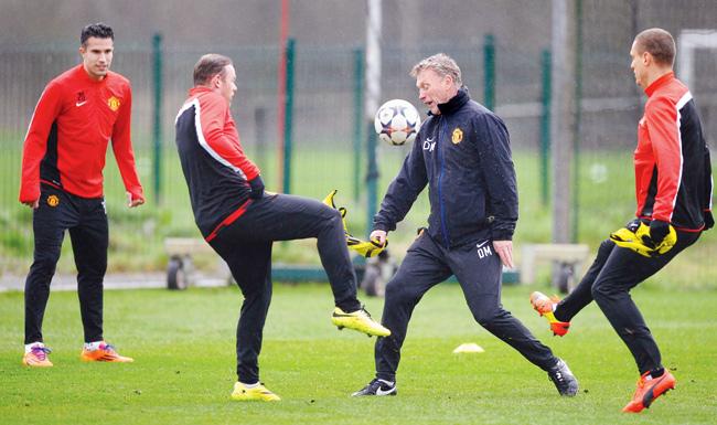 United boss David Moyes (second from right) challenges Wayne Rooney for the ball as Robin van Persie and Nemanja Vidic look on at a training session yesterday. Pic/Getty Images