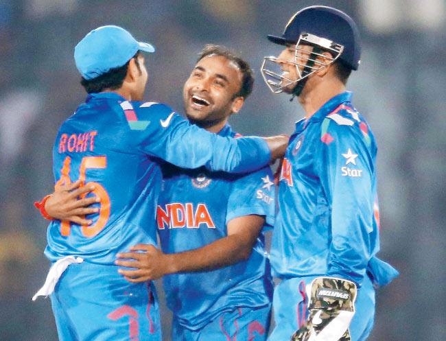 Amit Mishra celebrates the dismissal of Marlon Samuels with MS Dhoni (right) and Rohit Sharma in Dhaka yesterday. Pic/Getty Images