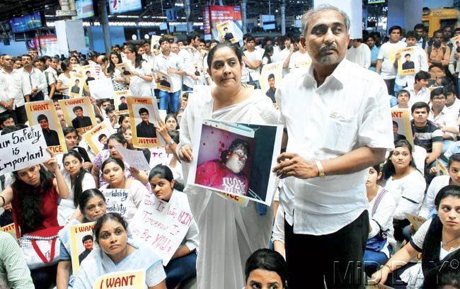 Dhaval Lodaya’s parents show a picture of their bleeding son during the protest at CST. The family submitted a letter to the DRM, blaming the railways for a delay in fetching an ambulance to the accident spot, which resulted in their son’s death. Pic/Sayed Sameer Abedi