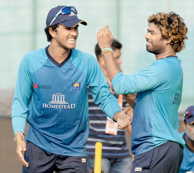 Lasith Malinga (right) with Dinesh Chandimal during a practice session yesterday