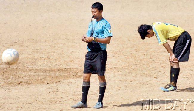 A referee officiates an MDFA Super Division game between Intelnet FC and Byculla United at the St Xavier