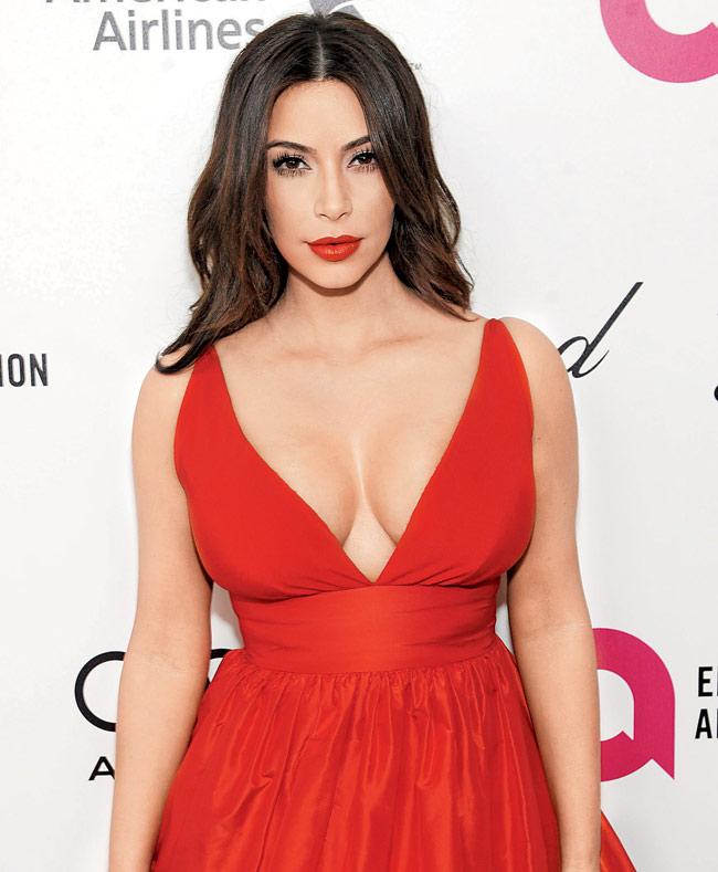 Reality star Kim Kardashian looks resplendent in a deep-cut crepe silk red gown that flaunts her assets