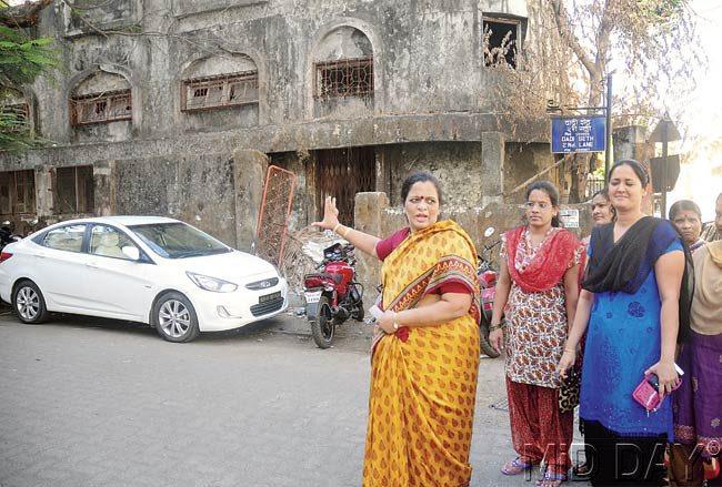 Principal Shobhana Anand and parents of children of BKM School point to the structure