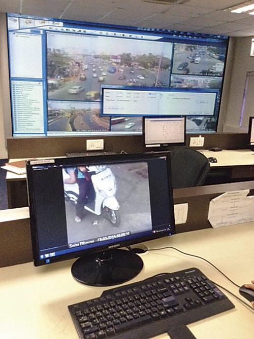 Cops watch the footage at the control room at traffic police headquarters in Worli
