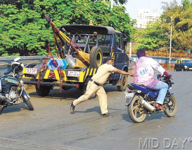 A traffic policeman lunges at a driver at Matunga Bridge, in course of a drive to crack down on unruly driving on Monday. Pic/Sayed Sameer Abedi