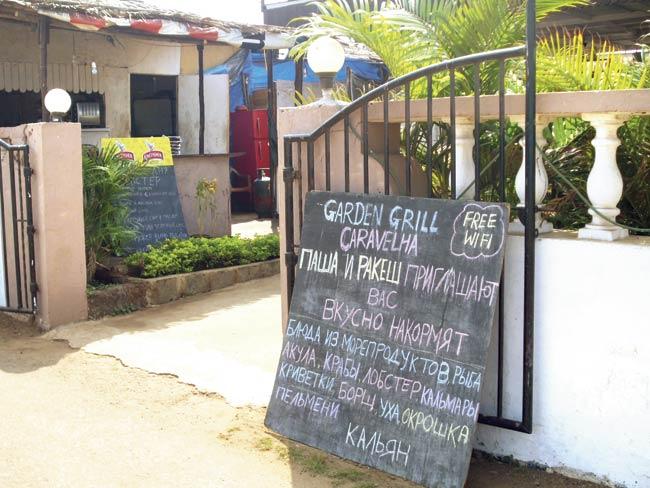 A typical scene outside a restaurant in Goa, with signboards in Russian offering tandoori chicken, king prawns, etc
