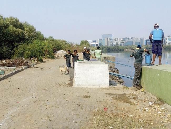 Workers remove waste from the Mithi every day