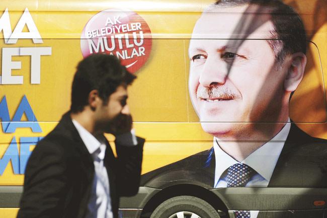 A man passes by a poster of Turkish Prime Minister Recep Tayyip Erdogan, who banned Twitter yesterday in the country. However, his move backfired, as the website was inundated with tweets from his country, criticising him. Pic/AFP