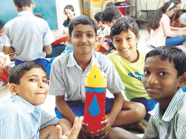 Children at SSRVM, Dharavi hold up a puppet they made from recycled materials