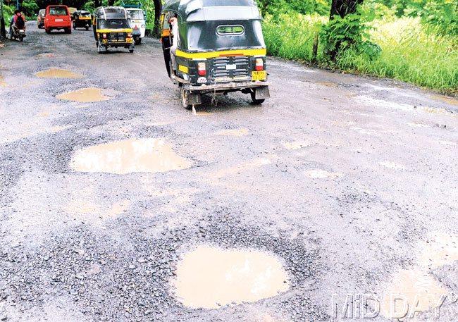 Bumpy ride: Vehicles steer clear of the larger potholes on the Aarey Colony link road on Tuesday. While the BMC is yet to repair older potholes on the road, heavy rainfall in the past few days have already led to new potholes appearing. Pic/Nimesh Dave