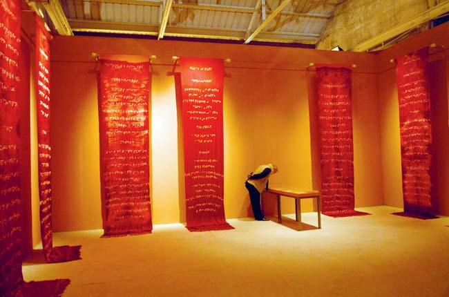 Walls of the Womb is a tied and dyed artwork that has silk brass, bonded marble, and handwritten recipe books as materials. The installation is 234 inches x 45 inches