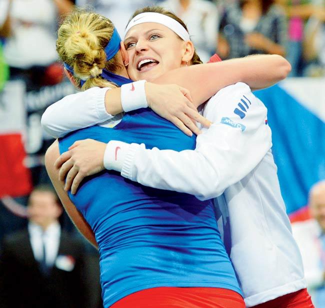 Petra Kvitova of Czech Republic (in blue) hugs teammate Lucie Safarova after beating Germany