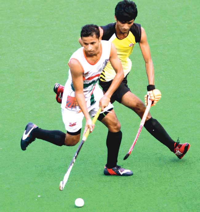 An Indian Navy player (left) tries to get past a WR player during their Bombay Gold Cup match at the MHAL Stadium yesterday