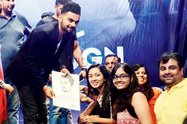 A fan presents India batsman Virat Kohli a portrait of himself during a promotional event in the city yesterday. Pic/Sayyed Sameer Abedi