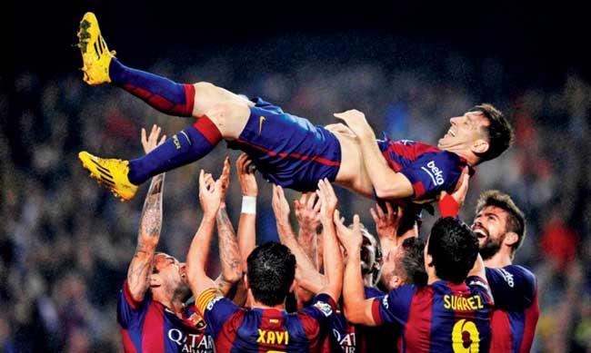 Barcelona players lift Lionel Messi after he became the all-time highest goal-scorer in La Liga on Saturday. Pic/AP/PTI