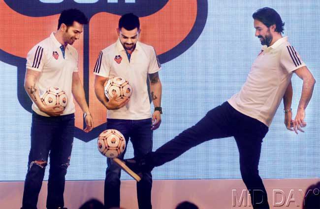 Goa marquee player Robert Pires (right) juggles a football as cricketer and co-owner of the club Virat Kohli and Bollywood actor Varun Dhawan (left) look on yesterday. Pic/Satyajit Desai