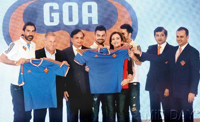 Marquee player Robert Pires (extreme left), coach Zico, Venugopal Dhoot, Virat Kohli, Nita Ambani, Varun Dhawan, Shrinivas Dempo and Dattaraj Salgaocar unveil the FC Goa jersey. Pic/Satyajit Desai