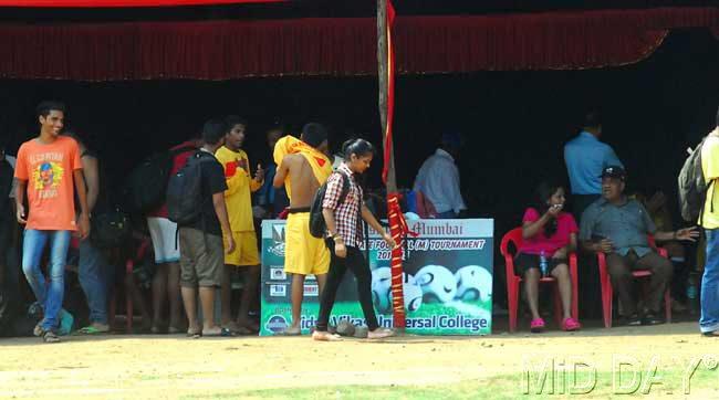 Players change in a shamiana which doubles up as a changing room at the Anna Bhau Sathe ground even as a girl walks past them. Pic/Sayyed Sameer Abedi