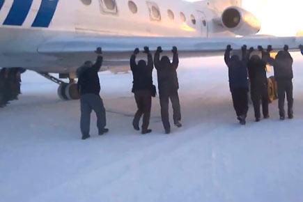 Watch video: Passengers get out and push frozen Siberian plane