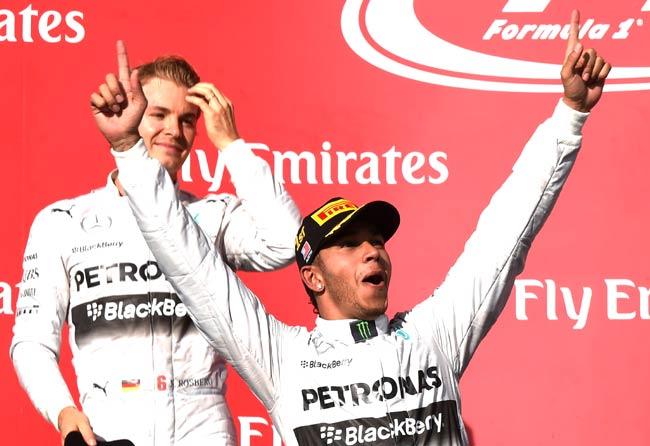 Mercedes AMG Petronas driver Lewis Hamilton of Britain (R) celebrates beside teammate Nico Rosberg of Germany on the podium after winning the United States Formula One Grand Prix at the Circuit of The Americas in Austin. Pic/AFP