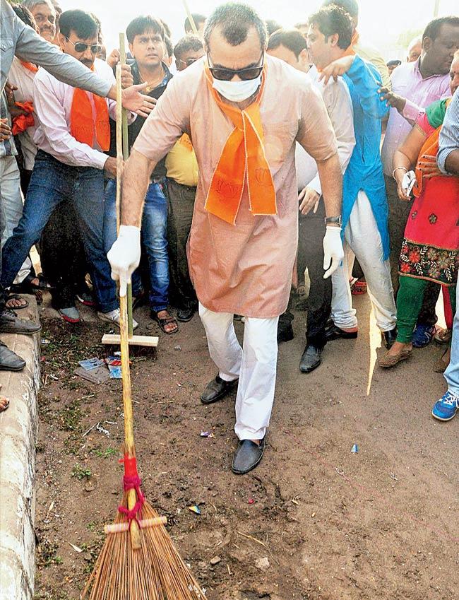 Paresh Rawal sweeps a road in Ahmedabad as a part of Swachh Bharat Abhiyan. Pic/PTI