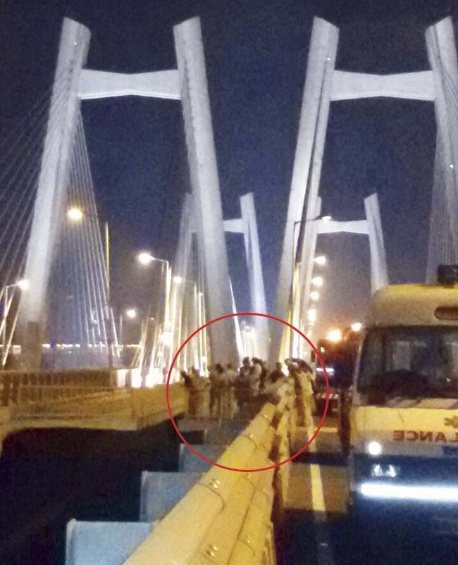 Cops stand near pole number 27 of the Bandra-Worli Sea Link, where the 20-year-old compounder had climbed atop a base of the pillar