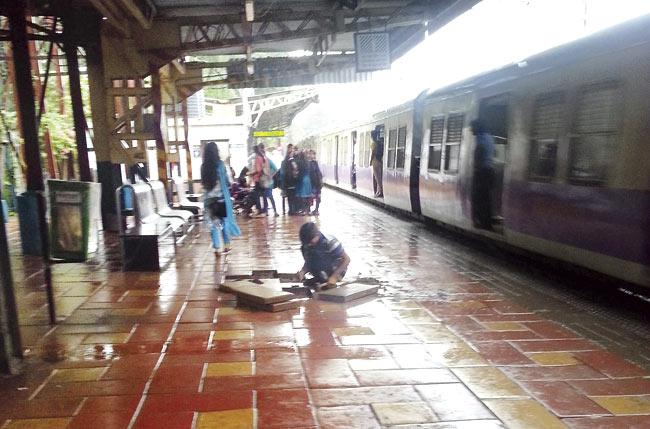 A labourer fixes tiles that have come off recently. It has been less than three months since the tiles were fitted on all the platforms